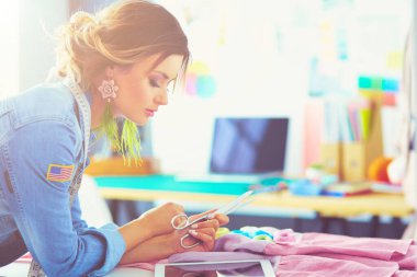 Moda Tasarımcısı kadın stüdyoda tasarımları ile iPad üzerinde.