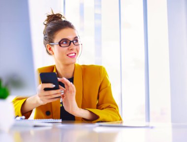 ofis telefon laptop ile oturuyor ve iş kadını.