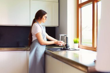 Su bardağını dolduran kadın elleri.