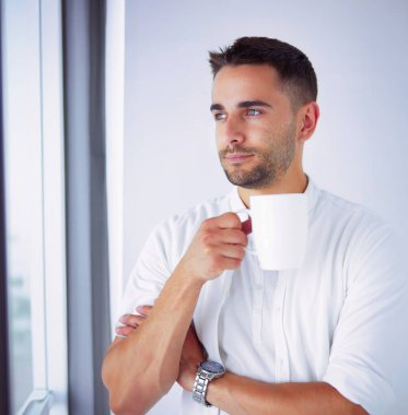 Genç iş adamı beyaz arka planda tek başına duruyor.