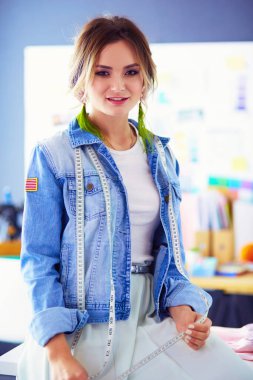 Moda tasarımcısı kadın stüdyoda tasarımları üzerinde çalışıyor..