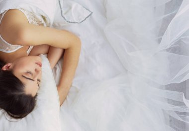 Güzel bir kadın yatağında uzanıyor..