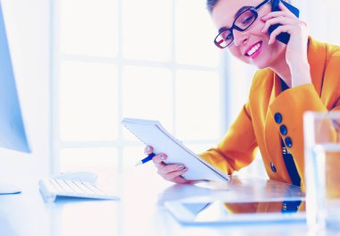 Güzel bir kadının portresi, iş yerinde dizüstü bilgisayarının önünde otururken ve yeni bir proje üzerinde çalışırken arama yapıyor.