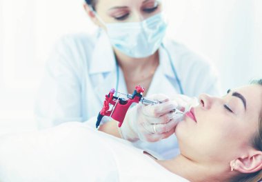 Kırmızı dudaklı genç bir kız kalıcı makyaj, mikro pigmentasyon.