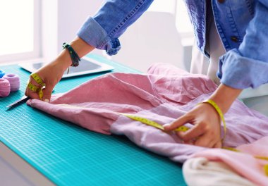 Moda tasarımcısı kadın stüdyoda tasarımları üzerinde çalışıyor..