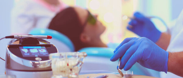 Man dentist working at his patients teeth.