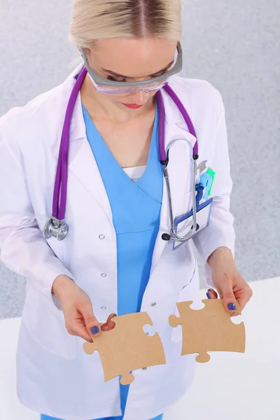 Woman Doctor Holding Two Connecting Puzzle Pieces — Stock Photo, Image
