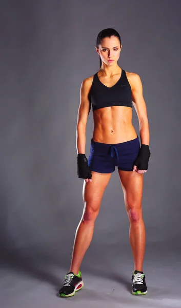 Muskulös Ung Kvinna Poserar Sportkläder Mot Svart Bakgrund — Stockfoto