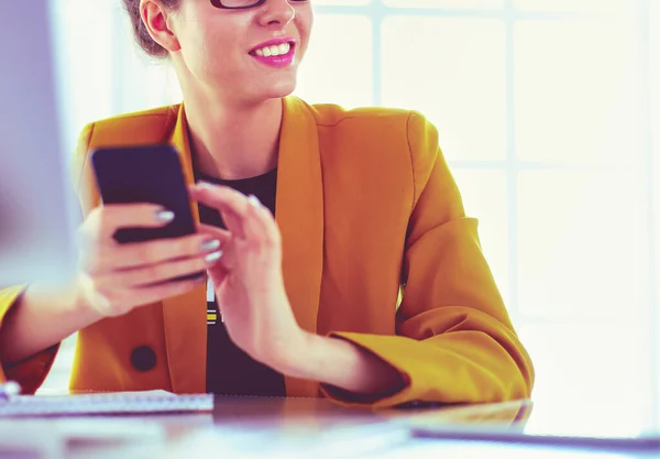 電話上のラップトップをオフィスに座っている女性実業家 — ストック写真