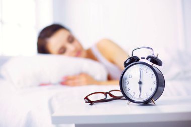 Genç ve güzel bir kadın yatakta yatıyor.