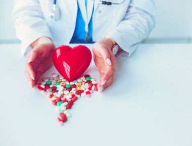 Masada kırmızı kalbi ve steteskopu olan kardiyolog..