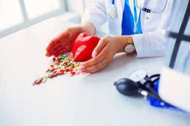 Masada kırmızı kalbi ve steteskopu olan kardiyolog..