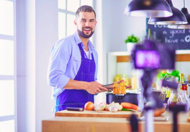 Mutfak arka planında poşet dolusu erzak tutan adam. Alışveriş ve sağlıklı gıda konsepti.