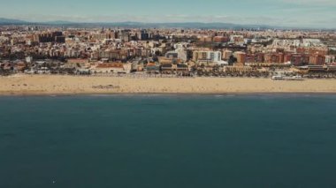 Bustling CoastA insansız hava aracı, güneşli bir sahil kentleri plajını ve kentsel gökyüzünü görüntüler. Güneşli bir günde City ve Expansive Beach. Yüksek kaliteli FullHD görüntüler