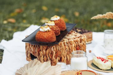 Renkli bir piknik masası, güneşin altında nefis tatlılar ve ferahlatıcı içeceklerle süslenmiş..