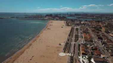 Valencia Sahili 'nde güneşli bir gün güneşli bir öğleden sonra Valencia Sahili' nin panoramik manzarası hareketli liman ve canlı şehir manzarasının yanında geniş kumlu sahili gösteriyor.