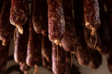 Geleneksel ev yapımı tütsülenmiş sosisler kurumak için asılı.