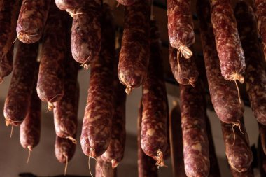 Geleneksel ev yapımı tütsülenmiş sosisler kurumak için asılı.