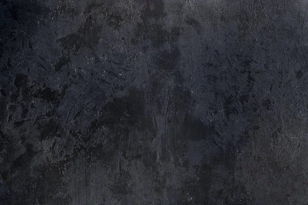 Old worn out black plastered wall texture, grunge background
