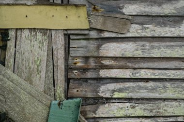 Geri dönüşümlü ahşap döşeme ve yıpranmış boyayla yapılmış eski bir kulübe duvarının detayları.