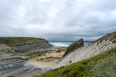 Pedruquios Koyu 'ndaki Cantabrian Denizi kıyısındaki erozyon, Costa Quebrada, Cantabria, Kuzey İspanya' daki kayalıklarda ve koylarda dalga hareketleriyle aşınan tortul kayalar ve araziler.