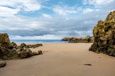 Playa Virgen del Mar, Costa Quebrada, Cantabria, Kuzey İspanya 'da tortulu kayalıkları olan güzel ve sessiz kumlu bir sahil.