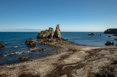El Castiellu sahilindeki Los Picones adasının kendine özgü kiremitleri alçak gelgitte görülebiliyor. Pendueles, Asturias 'ın batı kıyısı, Kuzey İspanya