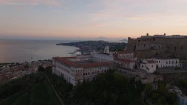 Şehir ve deniz kıyısında Chiostro Grande manastırı olan Castel SantElmo şatosunun havadan görünüşü. Renkli alacakaranlık gökyüzü. Napoli, İtalya.