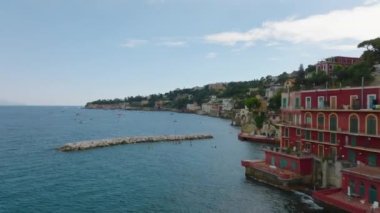 Popüler turizm beldelerinde denizlerin üzerinde uçarlar. İnsanlar suda güneşli bir günün tadını çıkarıyorlar. Sahil boyunca tarihi villalar ve saraylar. Napoli, İtalya.