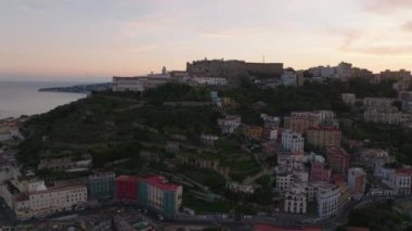 Şehrin yukarısındaki tepedeki tarihi kale Castel SantElmo 'nun hava manzarası. Alacakaranlıkta deniz kıyısını gösteriyorlar. Napoli, İtalya.