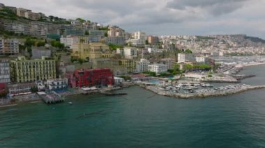 Deniz kıyısının yukarısındaki yamaçta parlak renkli binalar. Meşhur turist beldesindeki kaygan sahilin ifşası. Napoli, İtalya.