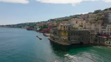 Deniz kıyısındaki tarihi DonnAnna Sarayı boyunca seyahat rotasında ilerliyorlar. Büyük sarayların renkli cepheleri. Napoli, İtalya.