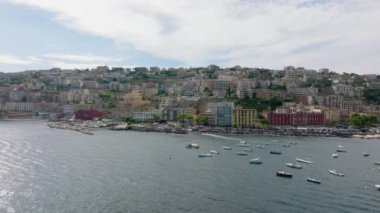 Deniz kıyısındaki lüks binaların panoramik manzarası. İleriye doğru su yüzeyinin üzerinden uçun ve rıhtıma doğru ilerleyin. Napoli, İtalya.