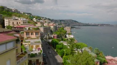 Su üstünde yüksek bir cadde. Deniz kıyısındaki lüks binalar seyahat noktasında. Parlak renk cepheleri ve yeşil bitki örtüsü. Napoli, İtalya.