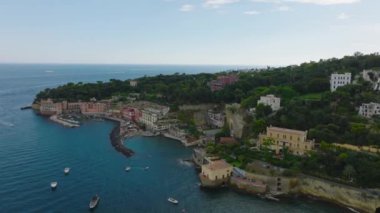 Deniz kıyısındaki lüks konutların hava panoramik görüntüleri. Anakaranın ucundan geçen sürat tekneleri. Napoli, İtalya.