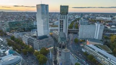 Şehir merkezindeki işlek caddelerin trafik saatinde havadan kayma ve yüksek hızda çekim. Kaiser Wilhelm Gedachtniskirche ve günbatımında modern yüksek binaların kalıntıları. Berlin, Almanya.