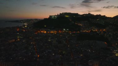 Renkli alacakaranlık gökyüzüne karşı tepedeki şato ve manastır siluetinin görüntülerini çekiyor. İyi akşamlar şehir manzarası. Napoli, İtalya.