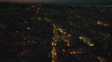 Gece yarısı Dante Meydanı 'ndan geçen araçların hava görüntüsü. Şehir merkezinde aydınlatılmış caddeler ve binalar. Napoli, İtalya.