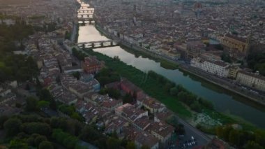 Arno nehrinin yüksek açılı manzarası eski kasabadan akıyor. Yukarı doğru eğildiğinde şehrin tarihi manzarası alacakaranlıkta ortaya çıkar. Floransa, İtalya.