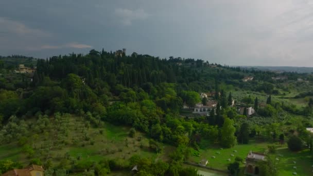 前方に高い木と大きな公園庭園と豪華な住宅の上に飛ぶ 都市郊外の風景です フィレンツェ イタリア — ストック動画