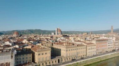 Arno nehir kıyısındaki sarayların havadan yükselen görüntüleri. Arkaplanda Katedral ve Palazzo Vecchio gibi tarihi simgeler var. Floransa, İtalya.