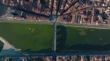 Şehirdeki Arno nehrinin üzerindeki köprüden kuş bakışı görüntü. Tarihi merkezdeki binaların çatısı ve dar sokaklar. Floransa, İtalya.
