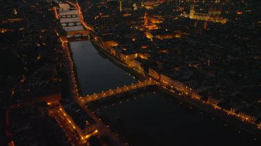 Arno nehri üzerindeki yüksek açılı köprü manzarası. Şehrin aydınlık manzaralı panoramik çekimini göster. Floransa, İtalya.