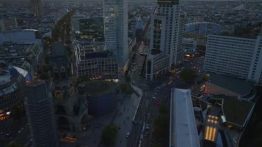 Günbatımında modern yüksek binaların ve eski kilisenin çevresindeki caddelerin hava manzarası. Charlottenburg Mahallesi, Berlin, Almanya.