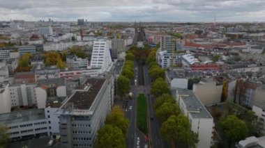 İleri, geniş bulvarın üzerinde ağaçlarla uçar. Kentsel yerleşim bölgesinin havadan panoramik görüntüsü. Charlottenburg Mahallesi, Berlin, Almanya.