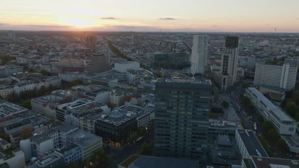 前方に大きな屋上メルセデスベンツのロゴと近代的な高層ビルの上に飛ぶ 日没の街の風景 ドイツ ベルリンのシャーロッテンブルク地区 — ストック動画