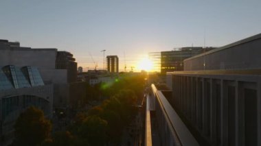 Şehir merkezindeki geniş caddedeki bina boyunca dar bir uçuş. Renkli günbatımına bak. Charlottenburg Mahallesi, Berlin, Almanya.