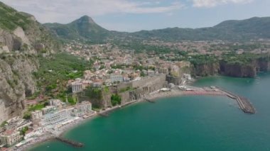 Yaz tatili varış noktasının hava kaydırak ve pan görüntüsü. Sahildeki sahil ve yamacın yukarısındaki tarihi kasaba. Amalfi, İtalya.