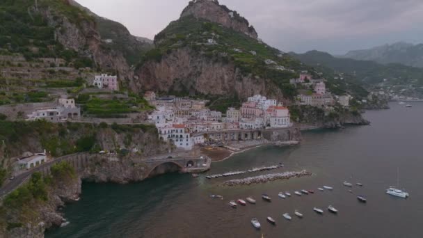 高い岩の崖の間に絞る小さな古い町の建物の空中スライドとパンショット Amalfi イタリア — ストック動画