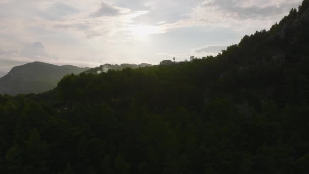 斜面で成長する高密度の緑の植生の上を飛ぶ 風景の中の尾根や谷を明らかにする 夕日に対して表示します Amalfi イタリア — ストック動画